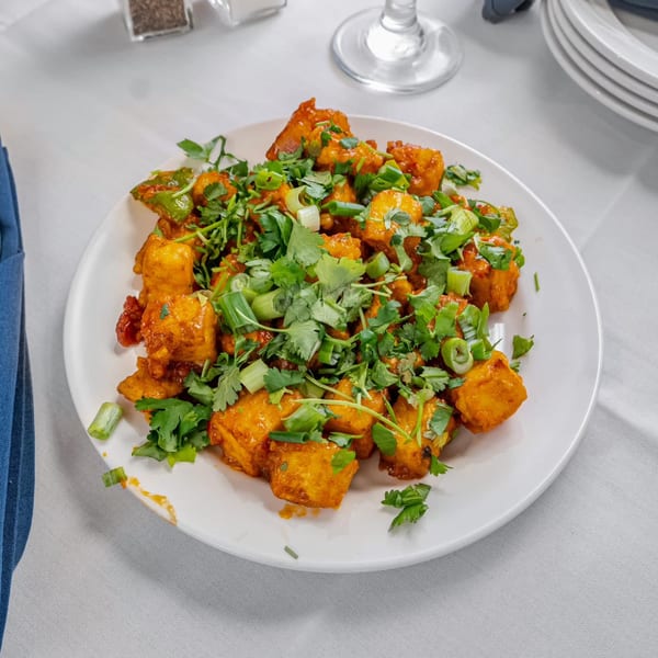 Indian chili paneer, golden fried and tossed in a spicy sauce, garnished with fresh cilantro and scallions.